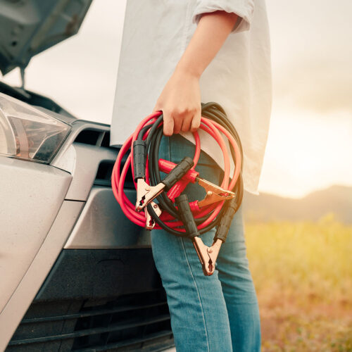 Close up Woman connecting battery cable copper wire for jumper repair and maintenance electric of engine car problem, broken her self service transportation, Vehicle stop engine between travel